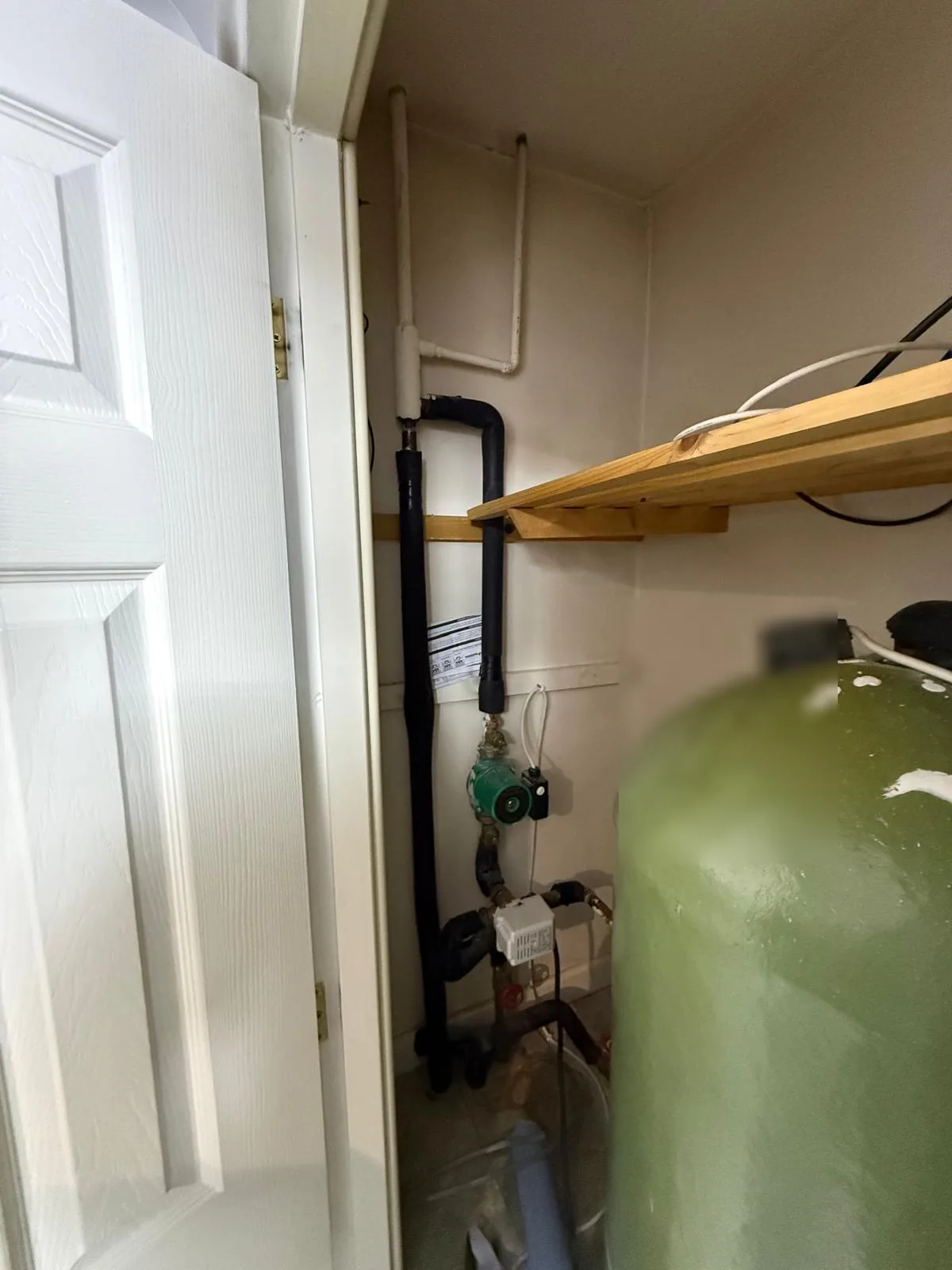 Old cylinder and pump in the cupboard before removal