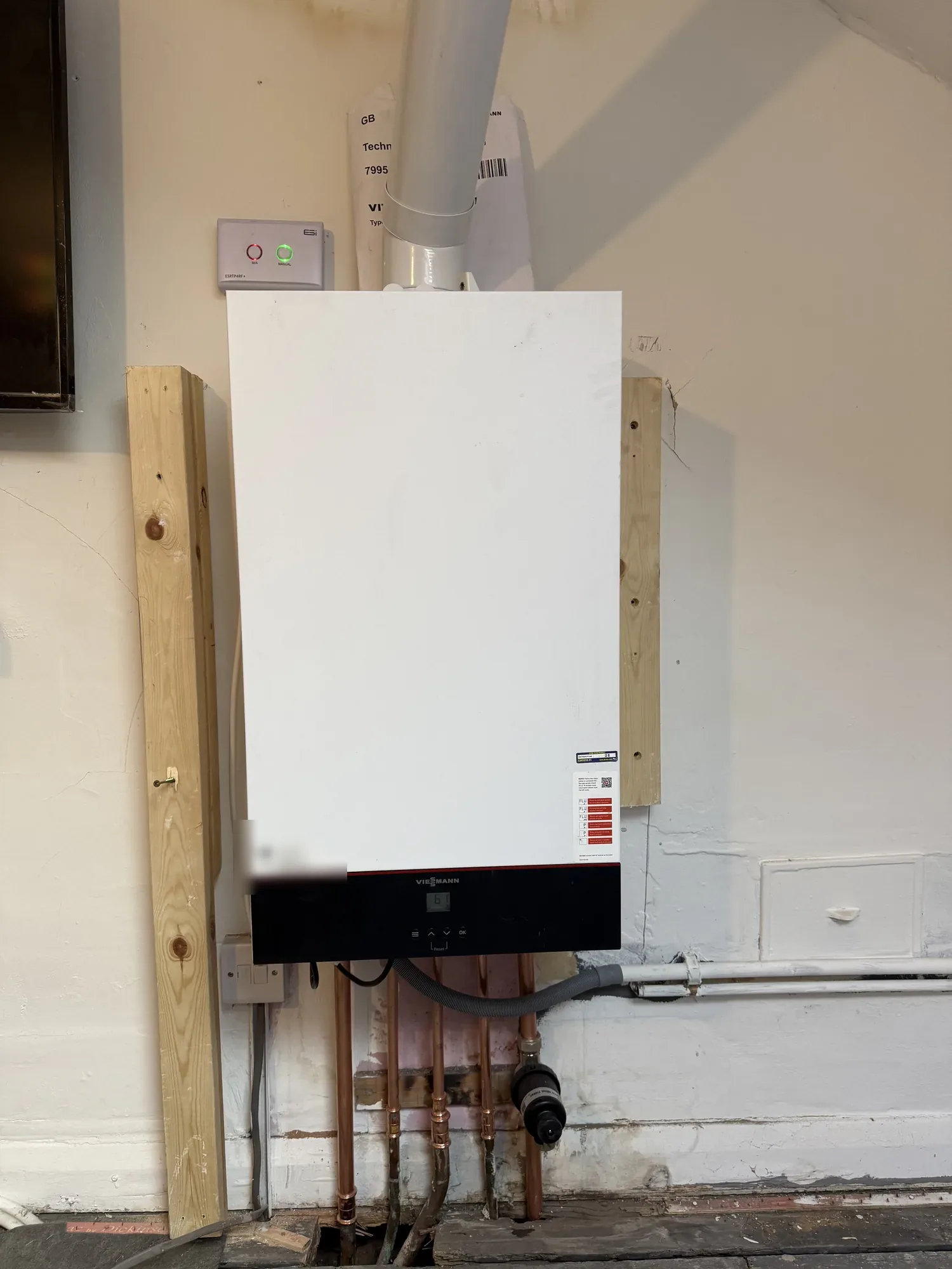 Wall-mounted combi boiler installed in a garage with new copper pipework