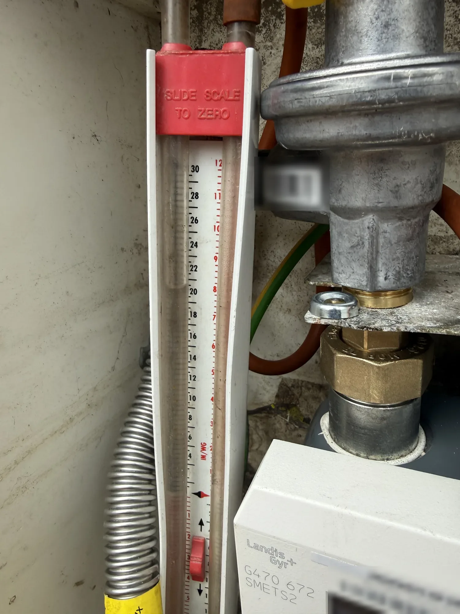 Gas meter and pressure gauge being checked during a service