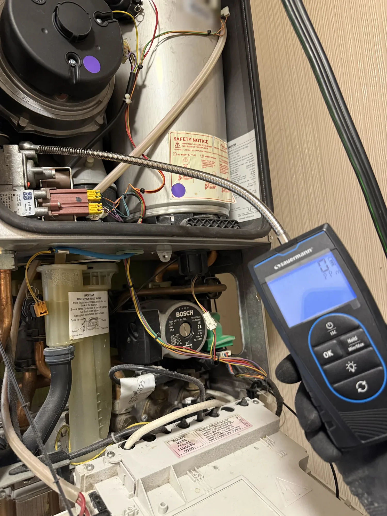 Gas leak detector checking a boiler during an annual service